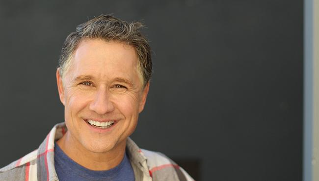 Close-up of a senior man standing and smiling