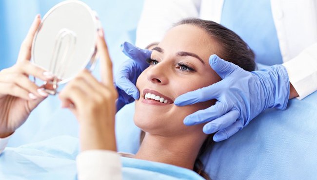 woman admiring the results of her direct bonding in the mirror 