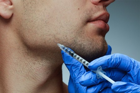 a man getting a BOTOX injection in his jaw