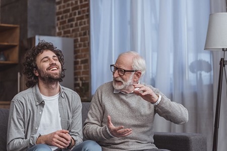 an older man speaking with a younger man