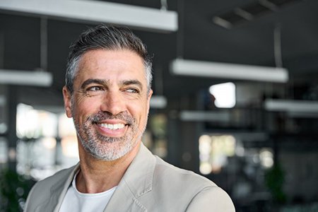 a man smiling while in an office