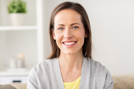 Woman smiling at home after visiting emergency dentist in Fort Worth, TX