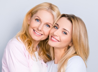 Smiling mother and daughter side by side