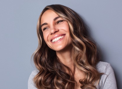 Smiling young woman in gray shirt