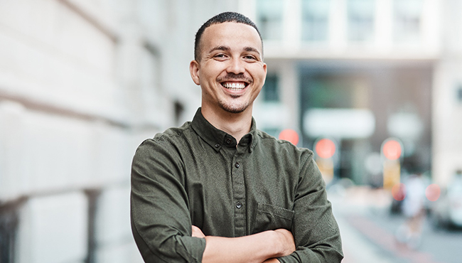 a man smiling with his arms crossed