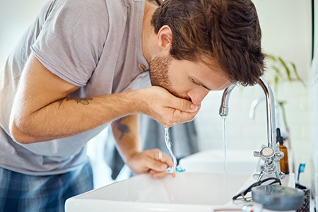 Patient rinsing with Peridex prescription mouth rinse