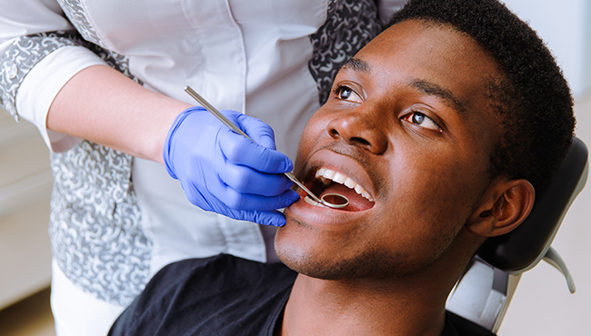 Man receiving dental checkup and teeth cleaning visit