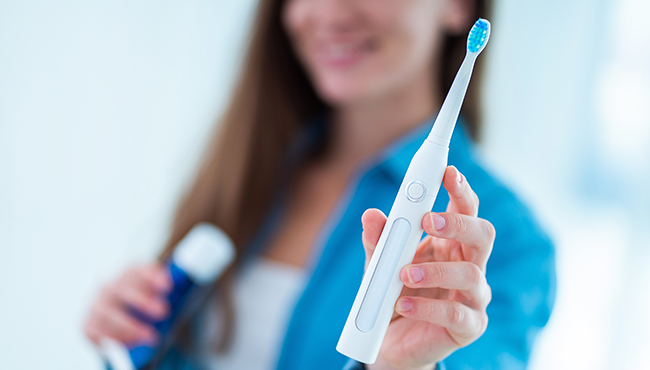 Woman holding an electric toothbrush