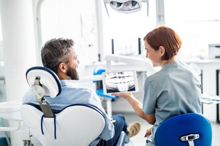patient talking to dentist about dental implants