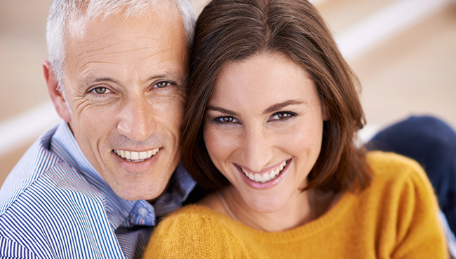 Man and woman smiling after dental crown restoration