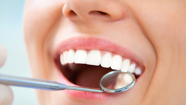 Dentist checking patient's tooth-colored filling restoration