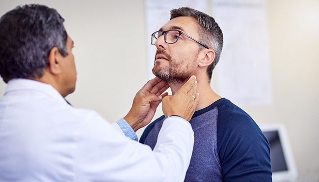 A patient receiving an oral cancer screening from a dentist