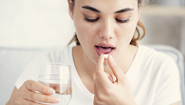 Woman taking oral conscious sedation dentistry pill