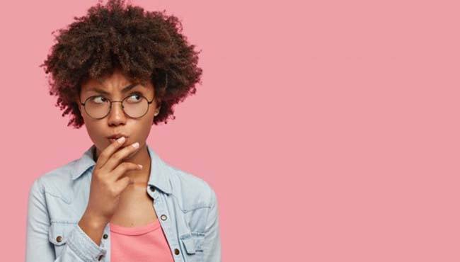 Woman on pink background wondering about veneers in Fort Worth