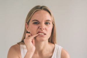 Woman pokes at her gums and wonders about gum health