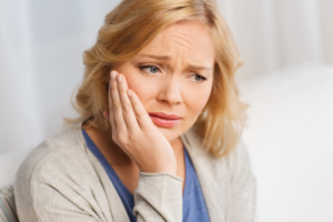 a woman in pain due to a dry socket 