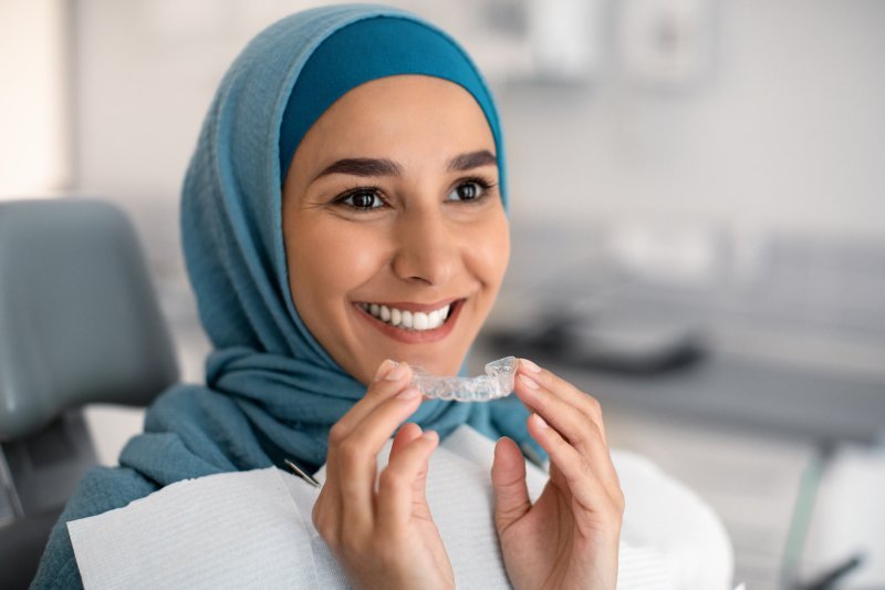 Girl smiling with her Invisalign tray 