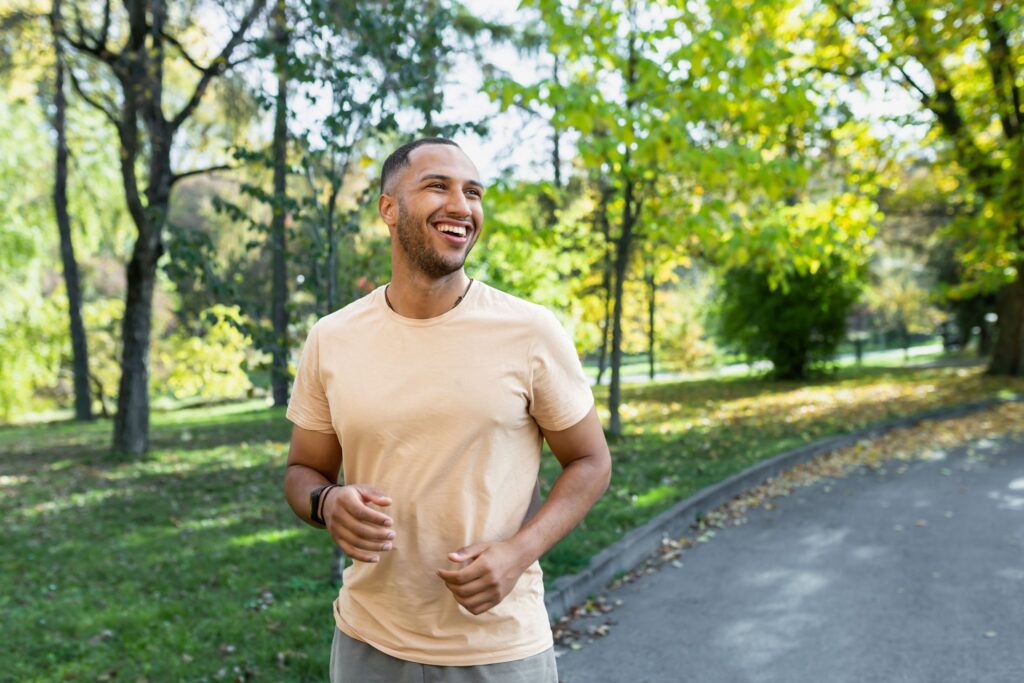 Man in yellow shirt walking outside on a sunny day